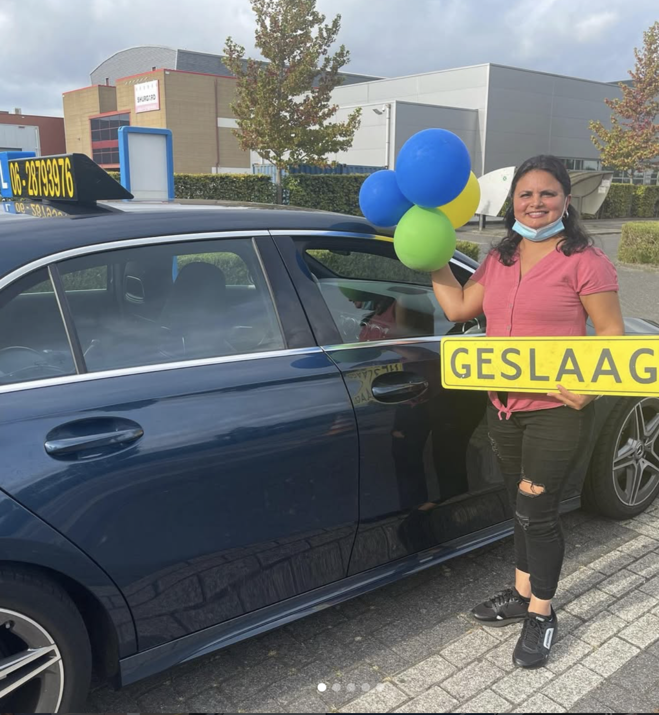 Geslaagde leerling van Autorijschool Altagracia met ballonnen naast de lesauto